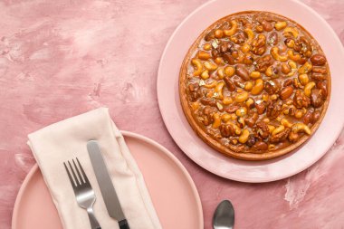 Farklı fındıklı tatlı tart ve pembe arka planda karamel.