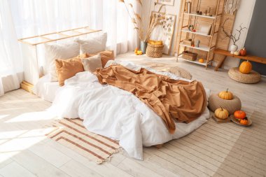 Yatak odasının içinde raf ünitesi, otlar ve balkabakları var.