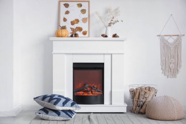 Beyaz şömineli, yastıklı ve balkabaklı şık bir oturma odası. Sonbahar konsepti