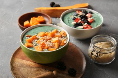 Gri arka planda lezzetli spirulina smoothie kaseleri
