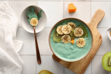 Fayans zemininde bir kase lezzetli spirulina smoothie.