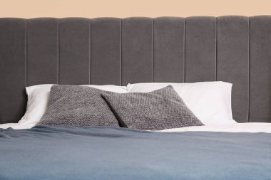 Şık yatak odasında yastıkları olan rahat bir yatak. Yakın çekim.