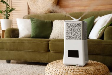 Modern hava nemlendirici, şık oturma odasında pouf 'ta.