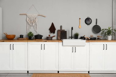 Beyaz tezgahlı, lavabolu ve çatallı bir mutfak.