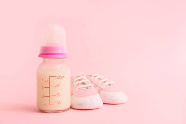 Bebek sütü formülü ve pembe arka planda şık popolar.