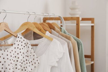 Rack with stylish clothes in dressing room, closeup