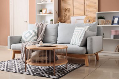 Gri kanepe, masa ve ahşap perdeli oturma odasının içi.