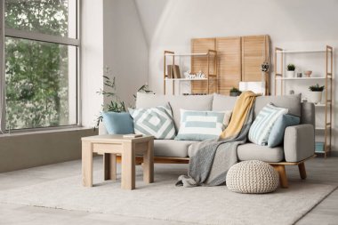 Katlanmış perdeli, kanepeli ve masalı bir oturma odası.