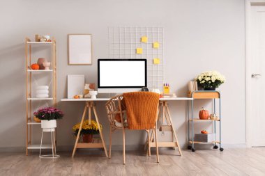 İş yeri, raf üniteleri ve kasımpatı çiçekleri ile ofis içi