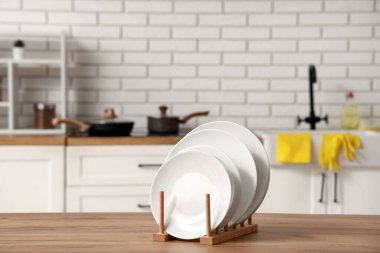 Mutfaktaki ahşap masaya temiz tabaklar koy.