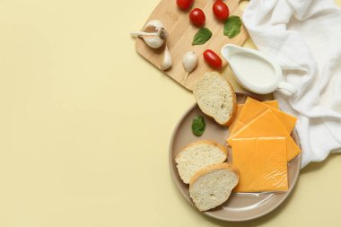 Üzerinde bej arka planda lezzetli işlenmiş peynir, ekmek ve domates dilimleri olan bir tabak. Üst görünüm