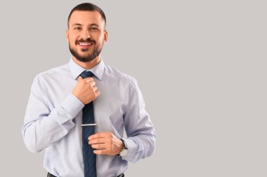 Genç işadamı arka planda kravatını düzeltiyor.