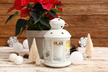 Fenerli kompozisyon, güzel Noel süslemeleri ve açık ahşap masa üzerindeki noktalama seti.