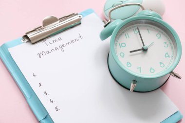 Pembe arkaplanda TIME MANAGEMENT, alarm saati ve bilgisayar faresi olan pano, yakın plan