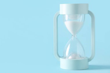 Mavi zemin üzerinde beyaz kum bulunan şık kum saati