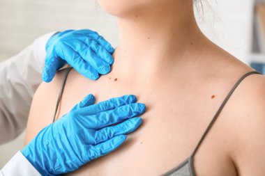 Klinikteki genç bayanı muayene eden doktor, yakın plan.