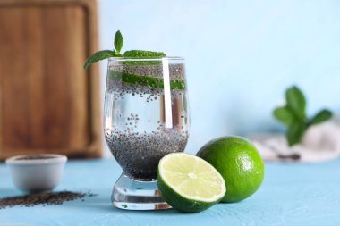 Mavi grunge arka planında Chia tohumlu, limonlu ve naneli bir bardak su.