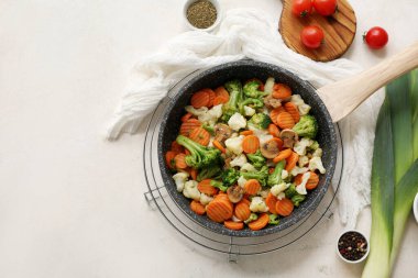 Beyaz arka planda kızarmış sebzeli kızartma tavası.