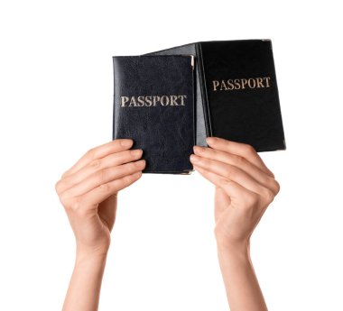 Pasaportları beyaz arka planda olan kadın eller, yakın plan.