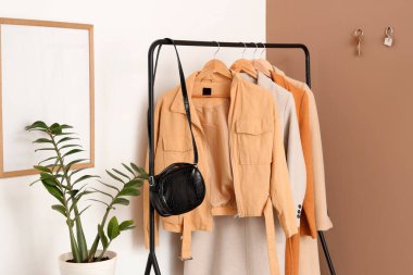 Elbise askısı ve anahtarların bej duvarda asılı olduğu şık bir salon.