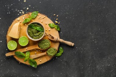 Bir kase dolusu lezzetli pesto sosu ve siyah grunge arkaplan içeriği.