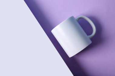 Renkli arka planda seramik beyaz bardak. Üst görünüm