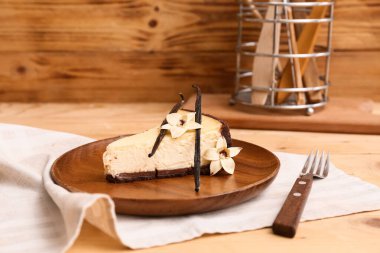 Tahta arka planda vanilyalı tatlı bir cheesecake tabağı