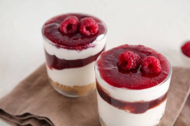 Beyaz arka planda lezzetli çilekli cheesecake bardakları, yakın plan.
