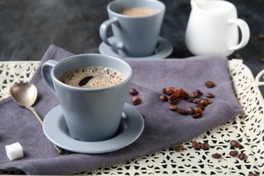 Yıldız anasonlu sıcak kahve ve siyah arka planda bir sürahi taze süt.