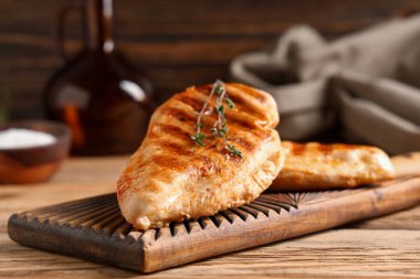 Lezzetli ızgara tavuk göğsü ve ahşap arka planda kekik.