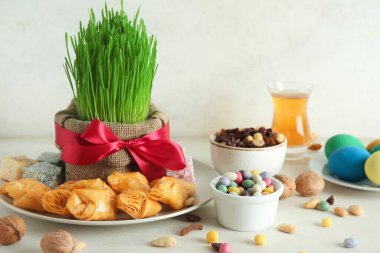Yeşil buğday çimi, geleneksel tatlı ve beyaz masada ceviz. Nowruz Bayram kutlaması