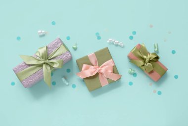 Hediye kutularında yılan yağı ve mavi arka planda konfeti.