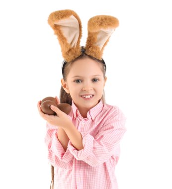 Beyaz arka planda çikolatalı yumurtaları olan tavşan kulaklı şirin bir kız. Paskalya kutlaması