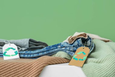 Yeşil arka planda geri dönüşüm logosu olan etiketler