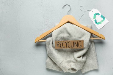 Gri arkaplanda süveter ve geri dönüşüm işareti olan askı