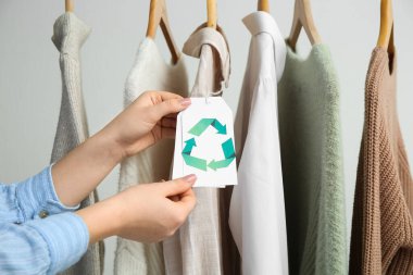 Beyaz arka planda geri dönüşüm etiketi tutan kadın