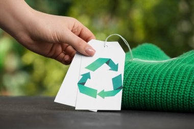 Masada geri dönüşüm için doğal giysileri olan bir kadın eli.