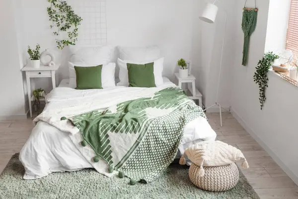 Masa ve yeşil bitkilerle aydınlık yatak odasının içi