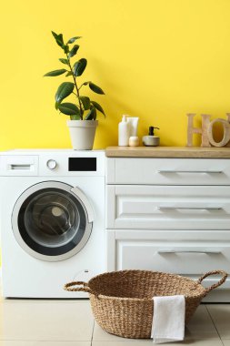 Çamaşır sepetinin, çamaşır makinesinin ve tezgahın olduğu odanın içinde.