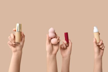 Bej arka planda kadın eli, sünger ve ruj.