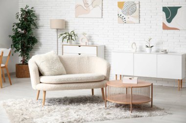 Beyaz kanepesi ve kahve masası olan modern oturma odasının şık bir iç mekanı.