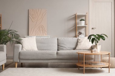 Gri kanepesi ve çiçekleri olan modern bir oturma odası.