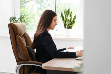 İşyerinde evrak işi yapan kadın ofis çalışanı.