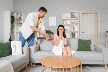 Cep telefonu olan koca ve evde ağlayan karısı. Hile konsepti