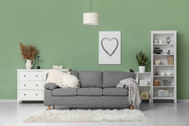 Rahat kanepesi, çekmeceleri ve raf ünitesi olan modern bir oturma odası.