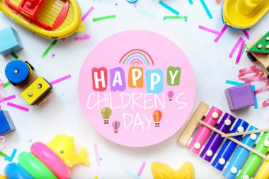 Beyaz masada farklı oyuncaklar ve boş kartlarla kompozisyon. Çocuk Bayramı kutlaması