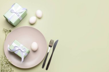 Yeşil arka planda hediyeler, çiçekler ve yumurtalarla güzel bir Paskalya masası.
