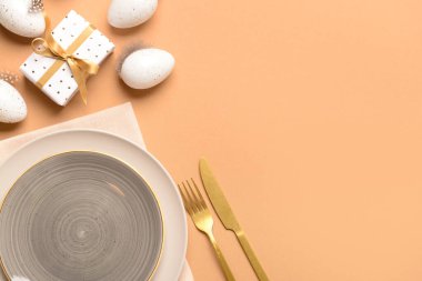 Bej arka planda yumurtalar ve hediyelerle süslü Paskalya sofrası.