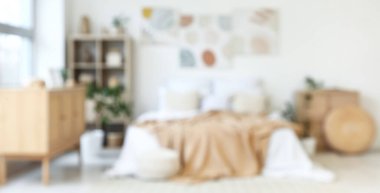 Şık yatak odası, rahat yatak, ev bitkileri ve güzel tablolar.