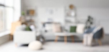 Koltukları ve bulanık manzarası olan şık bir oturma odası.